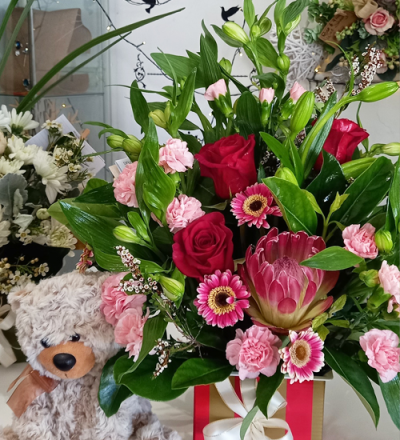 Head Over Heels - A enchanting container arrangement, created using the fresh blooms of the day in a mix of pink, red and white with complementary foliage.